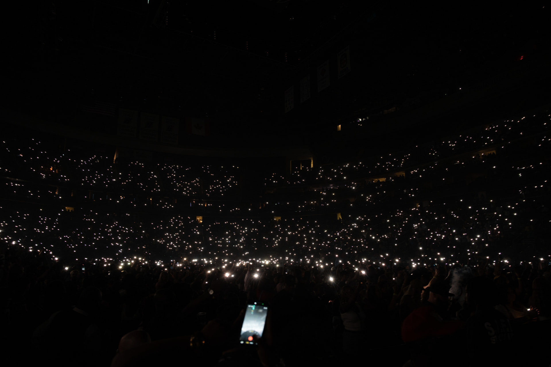 The Prudential Center crowd holding phone lights in the dark during Summer Jam 2026